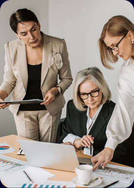 three professional women at table with tablet and sheets showing charts for successful development of assets with Crypto Asset Management
